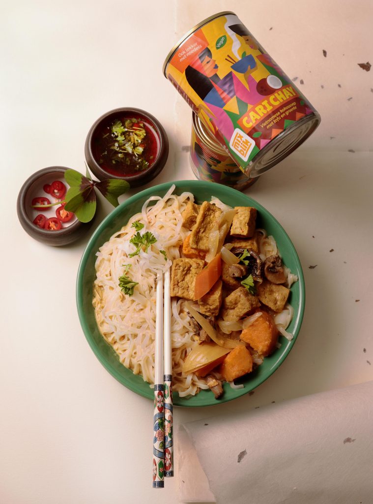 Mixblik Cari Chay blik, naast een Cari Chay noodle maaltijd in bord op tafel