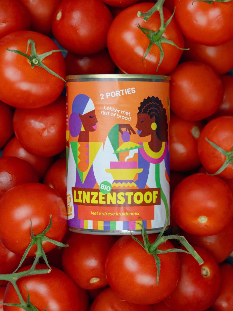Mixblik Linzenstoof blik met verse tomaten op de achtergrond.