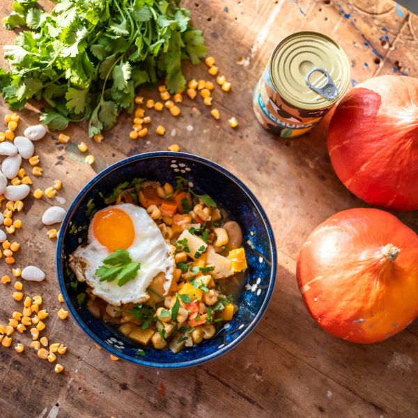 Cachupa gerecht Mixblik. Houten tafel met ingrediënten verspreid. Pompoen